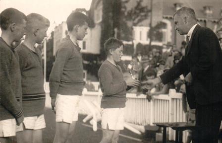 Charles Mackinnon receiving his prize at Preparatory School Sports, 1930.  <br/>Norman Morrison Memorial Hall in the background. (F Mackinnon)